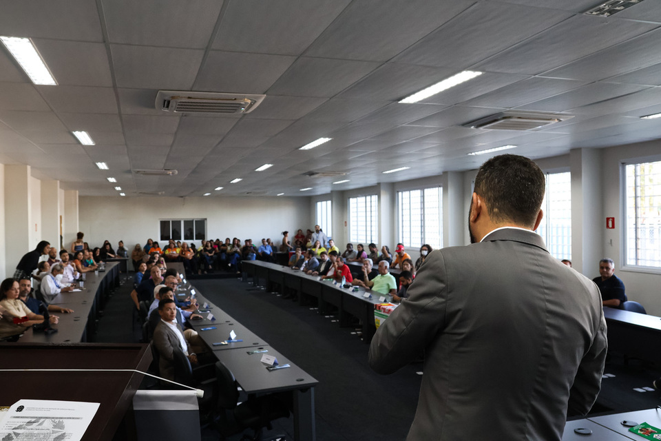 Auditório mostra um homem falando com o público de cima do palco
